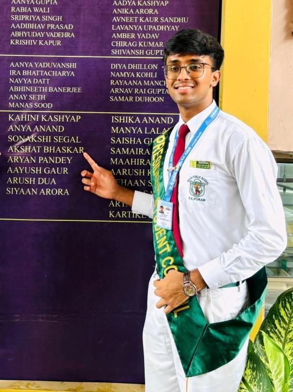 Akshat Bhaskar pointing to his name on the Delhi Public School R.K. Puram Wall of Fame