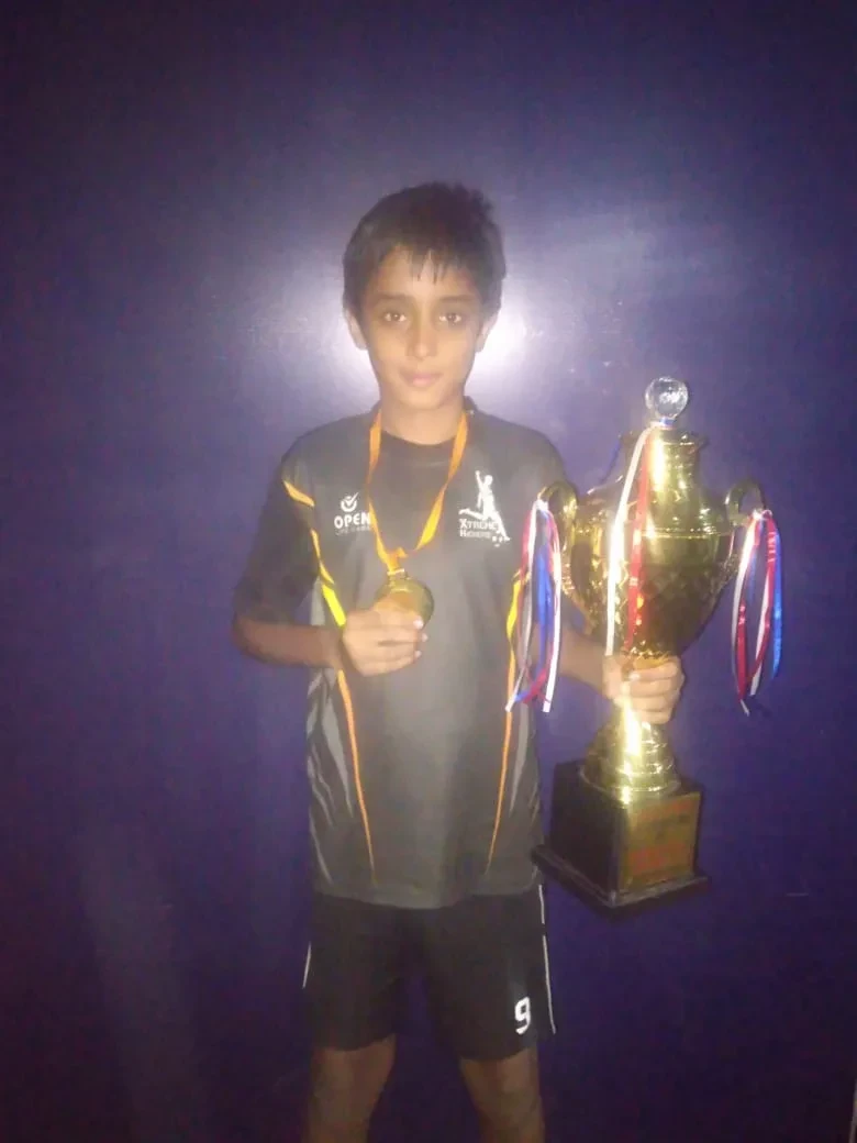 Holding a trophy and a medal after a football tournament