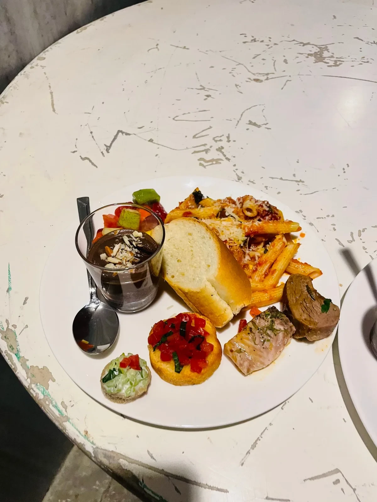 A plate of pasta, bread, bruschetta and chocolate mousse