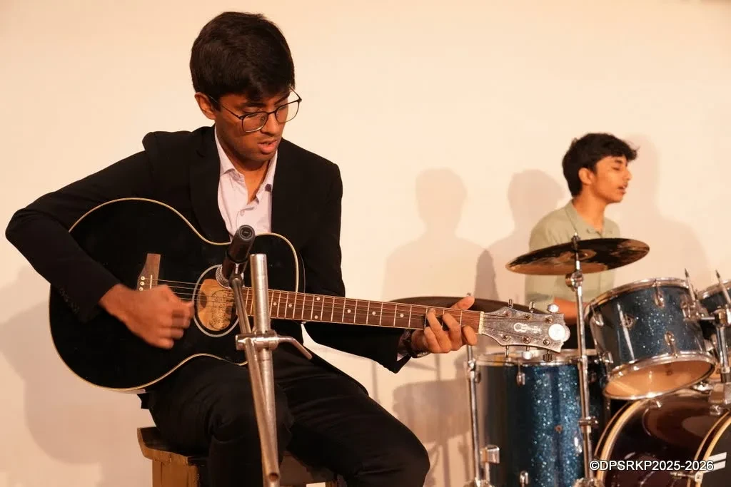 Playing guitar on stage with a drummer behind